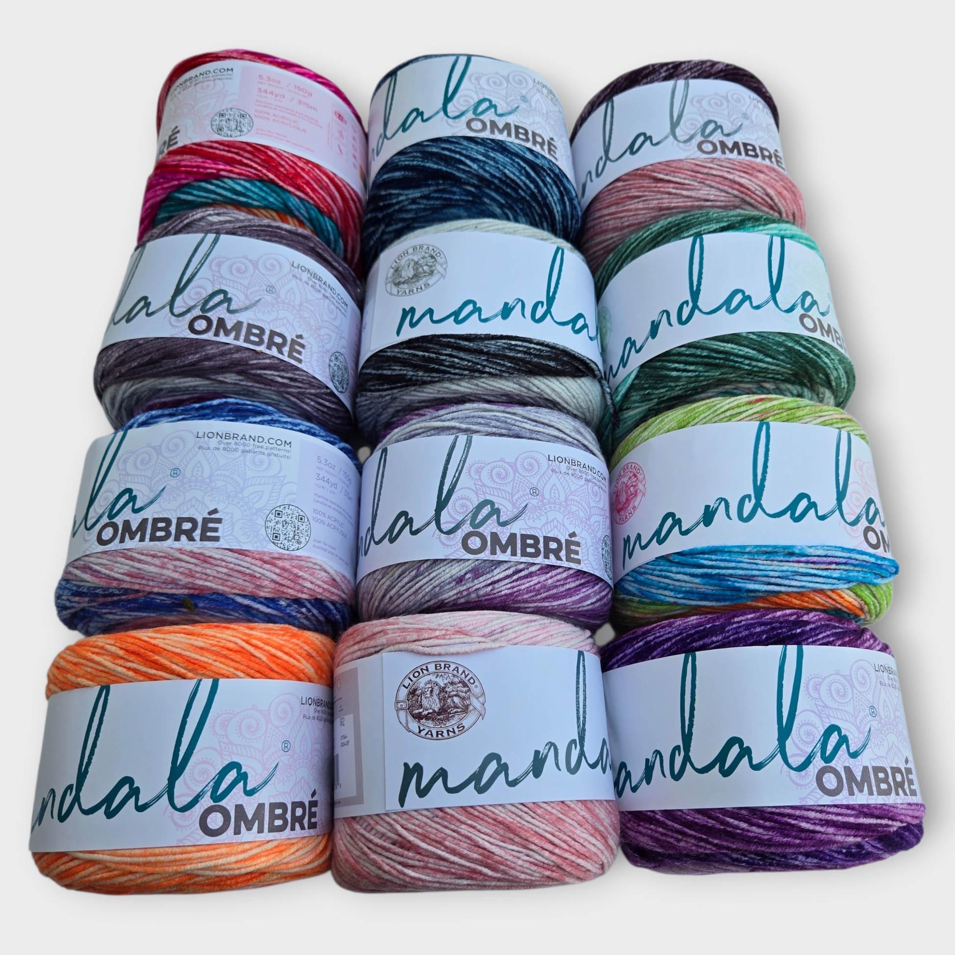 Stack of Mandala Ombre yarn with colorful skeins on a white background