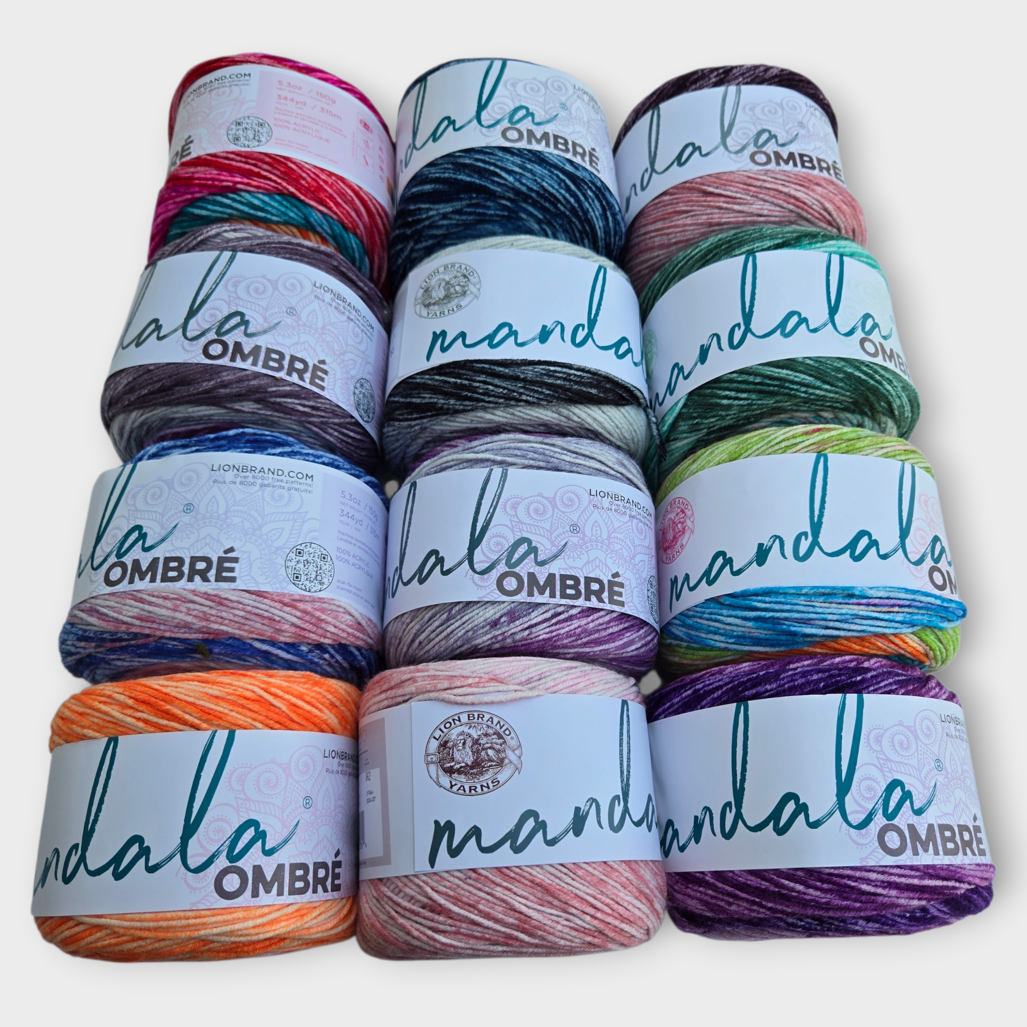 Stack of Mandala Ombre yarn with colorful skeins on a white background