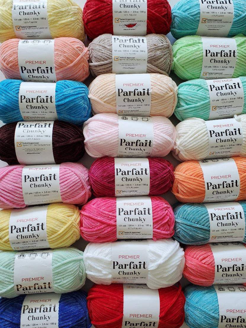Assorted balls of Parfait Chunky yarn in various colors on a white background